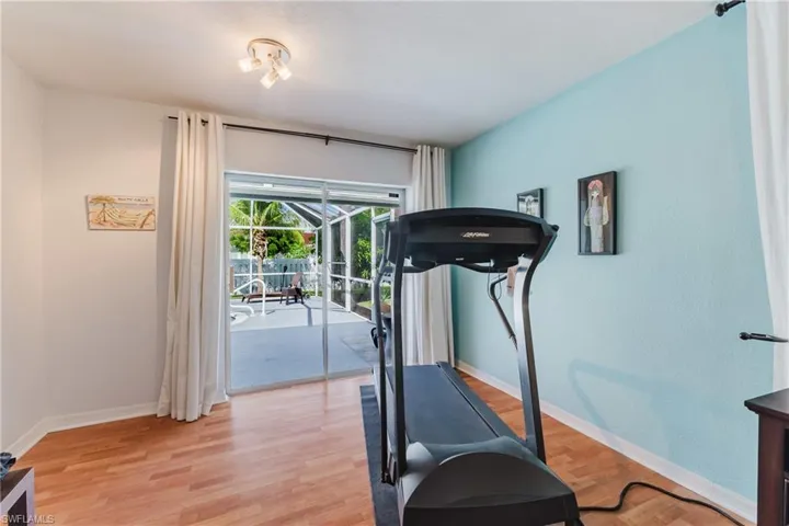 Exercise room featuring light wood-type flooring and baseboards