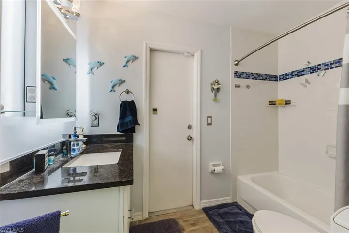 Full bath with shower / bathtub combination, vanity, light up mirror with bluetooth and light wood-style floors