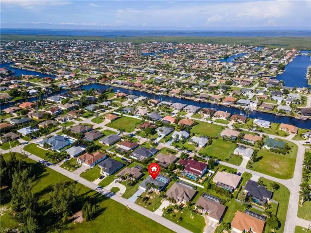 Aerial view of property's location with a large body of water and nearby suburban area