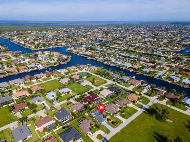 Aerial view of property's location featuring a large body of water and nearby suburban area
