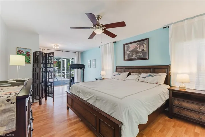 Bedroom with light wood-type flooring, access to exterior, and a ceiling fan