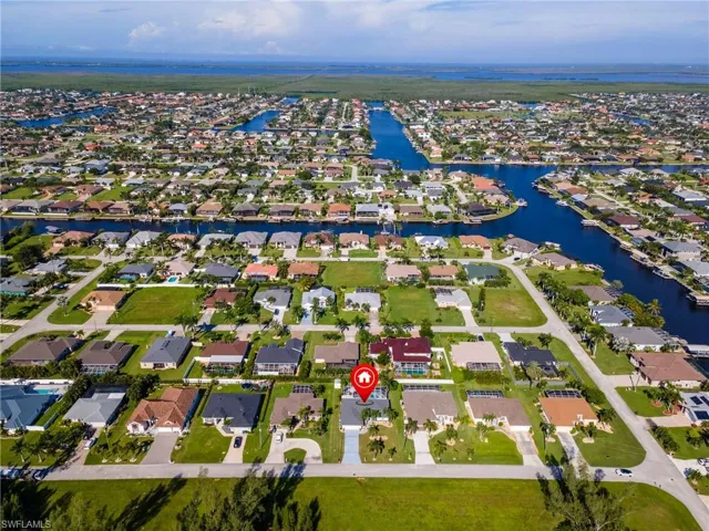 Aerial perspective of suburban area featuring a nearby body of water
