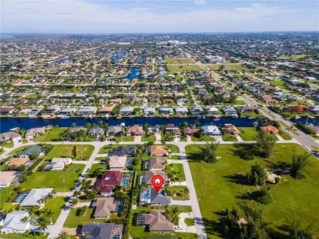 Aerial view of property and surrounding area featuring nearby suburban area