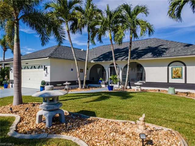Ranch-style house featuring stucco siding, a garage, roof with shingles, and a front lawn