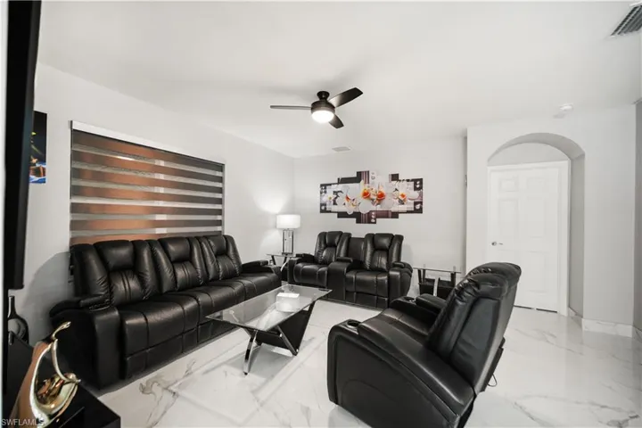 Living room featuring ceiling fan and light tile flooring