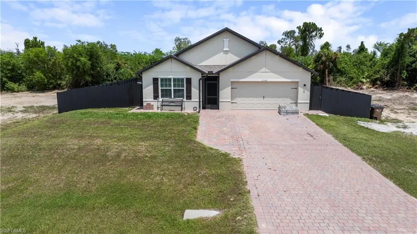 View of front of property featuring a garage and a front lawn
