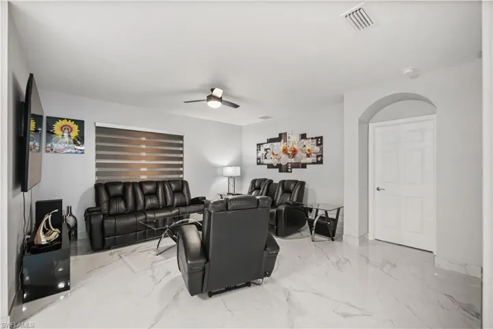 Living room featuring ceiling fan and light tile floors
