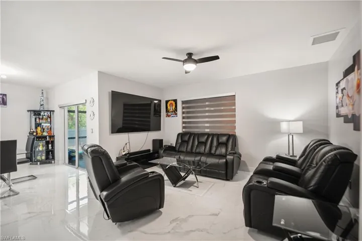 Living room with ceiling fan and light tile floors