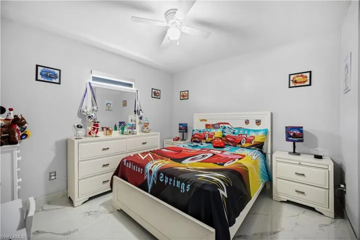Tiled bedroom featuring ceiling fan