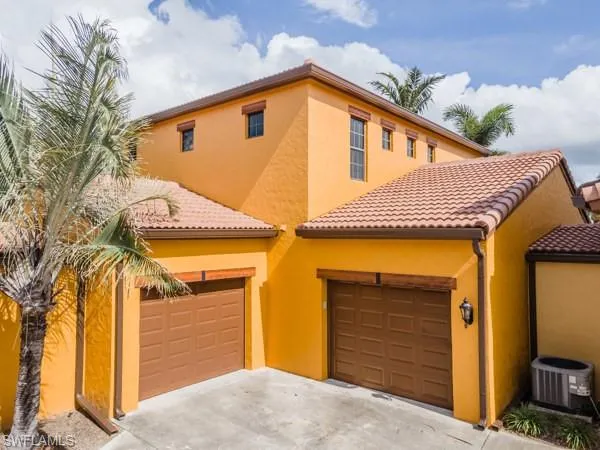 Mediterranean / spanish home with central air condition unit and a garage