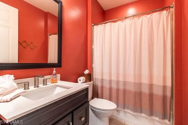Full bathroom featuring tile patterned flooring, vanity, toilet, and shower / tub combo with curtain