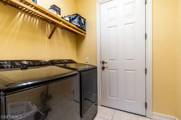 Washroom featuring light tile patterned floors and separate washer and dryer