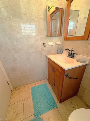 Bathroom with vanity and tile walls