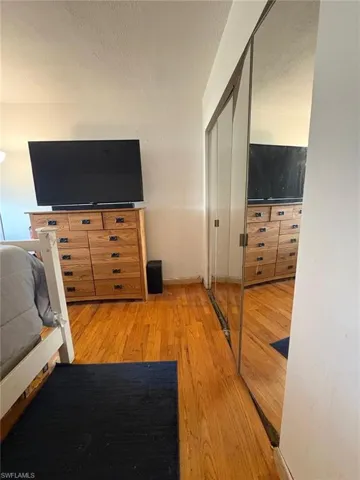 Bedroom with a closet, light wood finished floors, and a textured ceiling