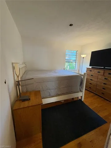 Bedroom with light wood-style floors and a textured ceiling