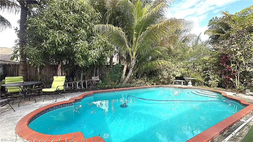 View of swimming pool with patio surround and a fenced backyard