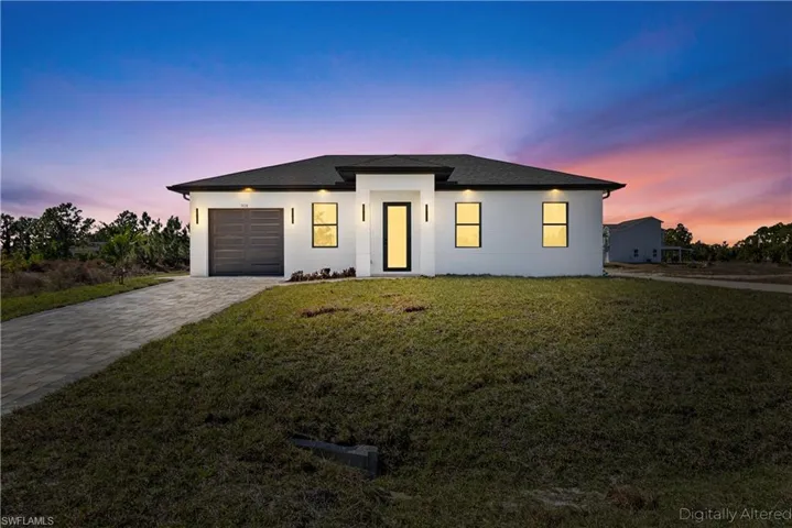 View of front of home with a lawn, decorative driveway, an attached garage, and stucco siding