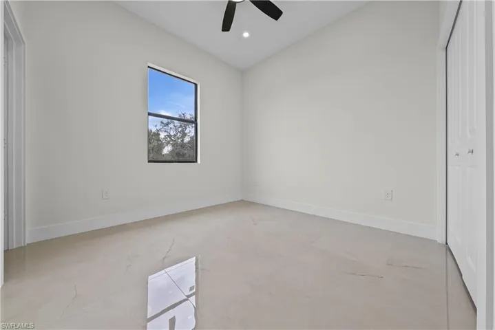 Unfurnished bedroom featuring a closet, vaulted ceiling, a ceiling fan, recessed lighting, and concrete floors