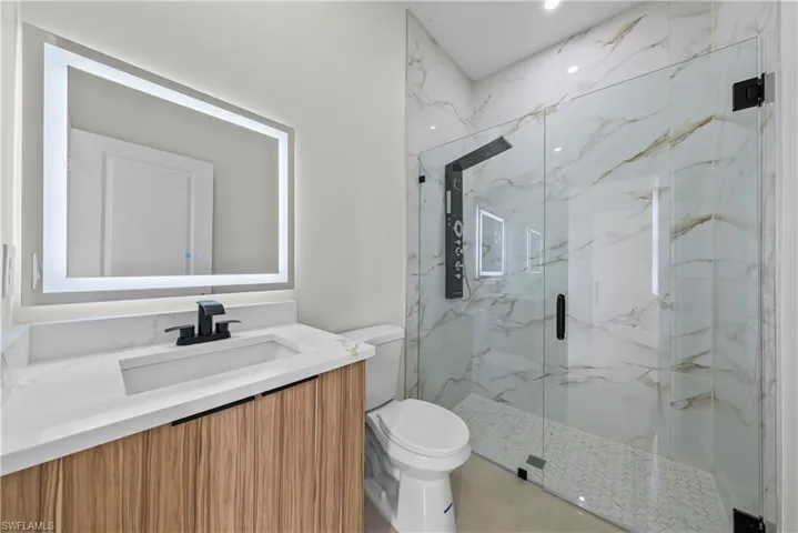 Full bathroom with a marble finish shower and vanity