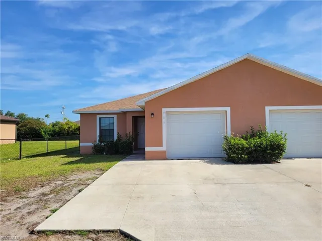 Ranch-style house with stucco siding, driveway, and a garage
