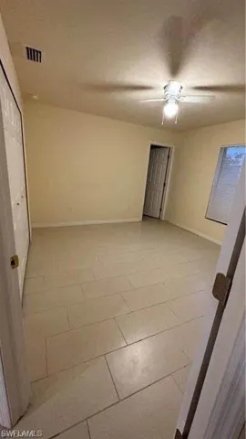 Empty room with a ceiling fan and baseboards