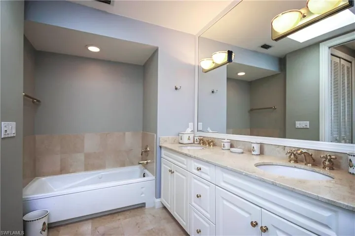 Bathroom featuring double vanity and  separate soaking tub
