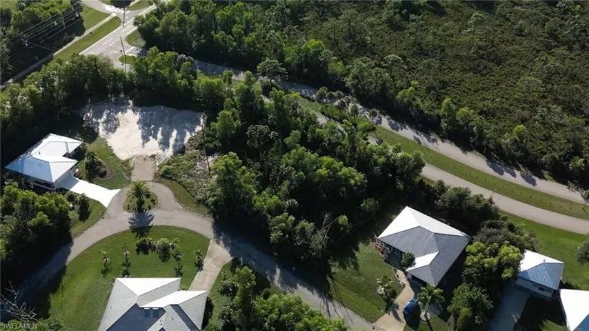 Aerial view of property and surrounding area featuring a forest