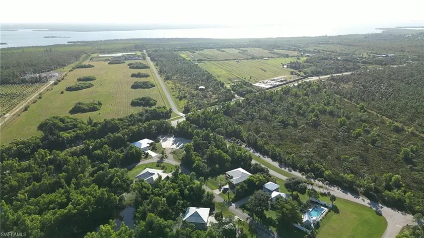 Aerial view of property and surrounding area with a nearby body of water and rural landscape