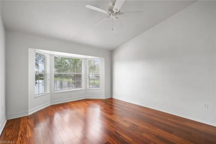Spare room featuring a textured ceiling, wood-type flooring, vaulted ceiling, and ceiling fan