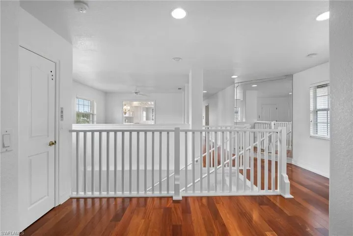 Hall with hardwood / wood-style floors and a healthy amount of sunlight