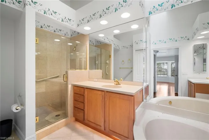 Bathroom with vanity, separate shower and tub, and tile patterned flooring