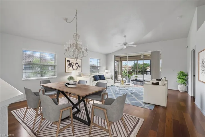 Dining area featuring lofted ceiling, dark hardwood / wood-style floors, and ceiling fan with notable chandelier