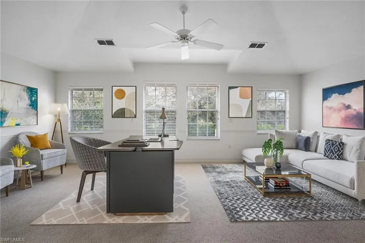 Living room with ceiling fan, a healthy amount of sunlight, and light carpet
