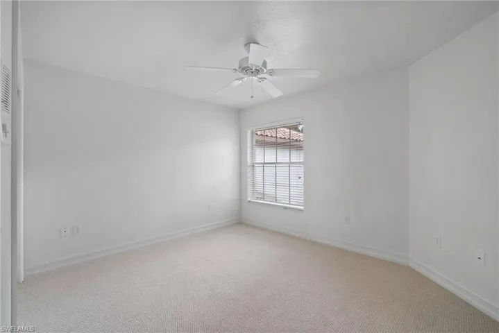 Unfurnished room with ceiling fan and light colored carpet