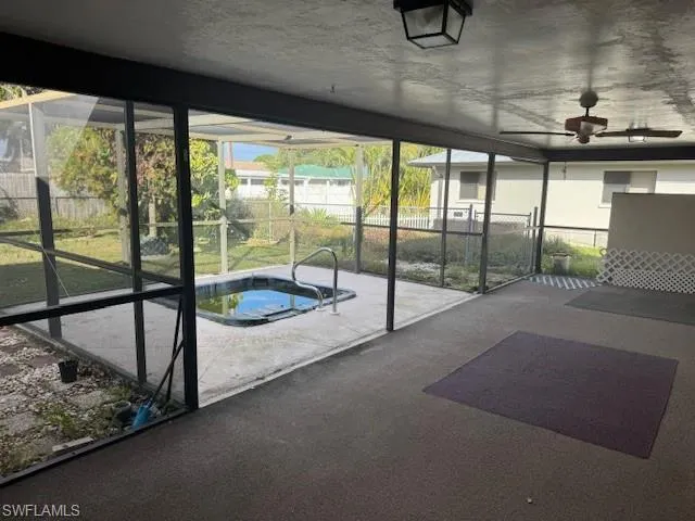 Unfurnished sunroom featuring ceiling fan