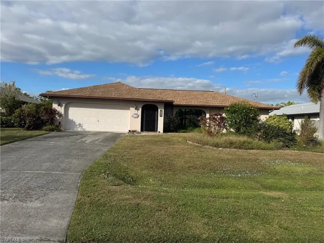 Single story home featuring a front yard and a garage
