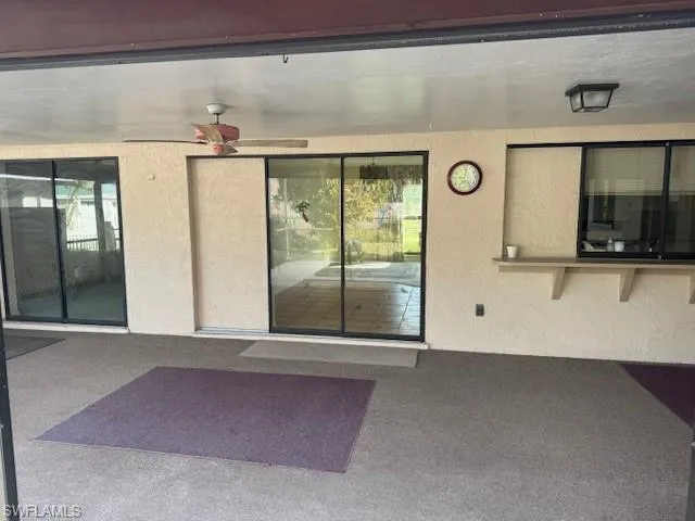 Doorway to property with ceiling fan