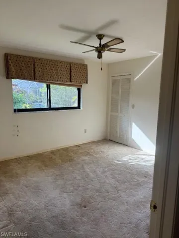 Spare room with ceiling fan and light colored carpet