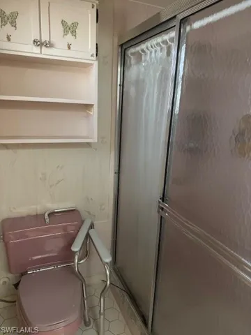 Bathroom featuring tile patterned floors, toilet, and walk in shower