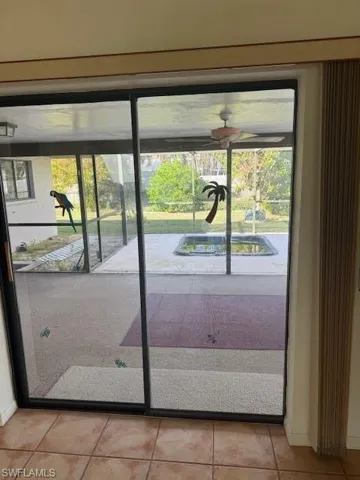 Doorway featuring light tile patterned flooring