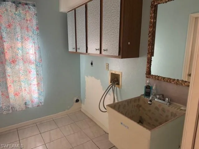 Laundry area with cabinets, washer hookup, electric dryer hookup, and light tile patterned flooring