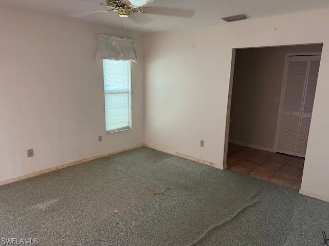 Carpeted spare room featuring ceiling fan