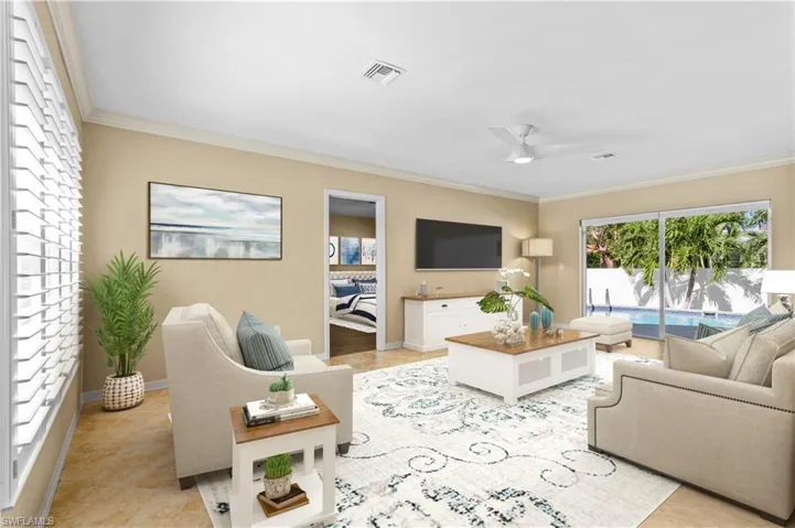 Tiled living room with ornamental molding and ceiling fan