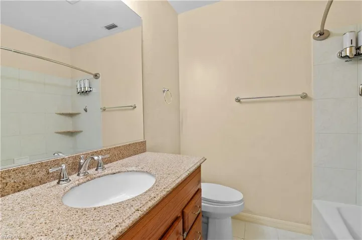 Full bathroom with tiled shower / bath, vanity, toilet, and tile patterned flooring
