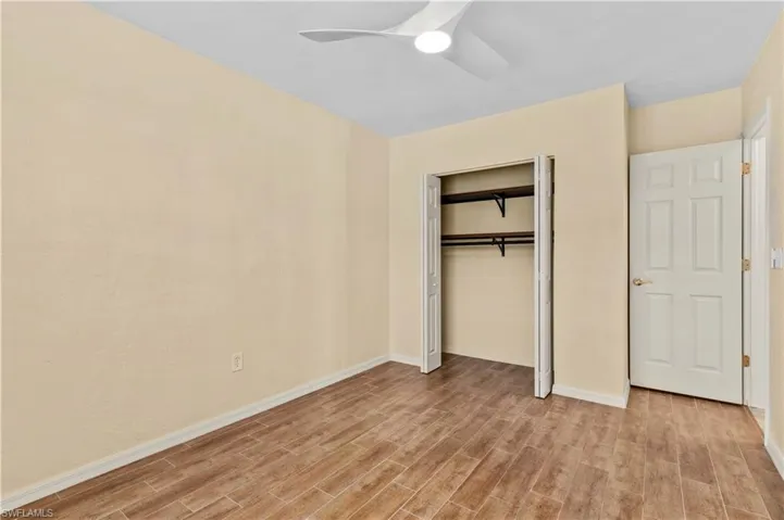 Unfurnished bedroom with light hardwood / wood-style flooring, a closet, and ceiling fan