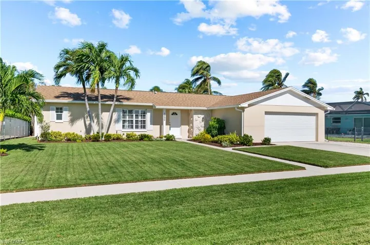 Ranch-style home with a front yard and a garage