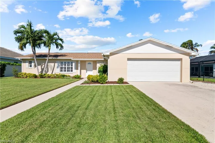 Single story home featuring a front yard, glass enclosure, and a garage