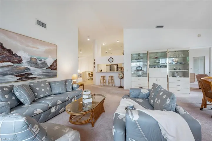 Living area with carpet floors and high vaulted ceiling