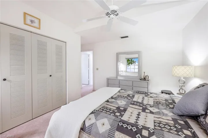 Carpeted bedroom featuring a closet and ceiling fan