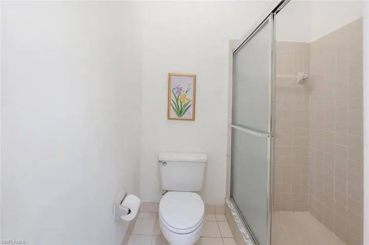 Full bath with a shower stall and light tile patterned floors